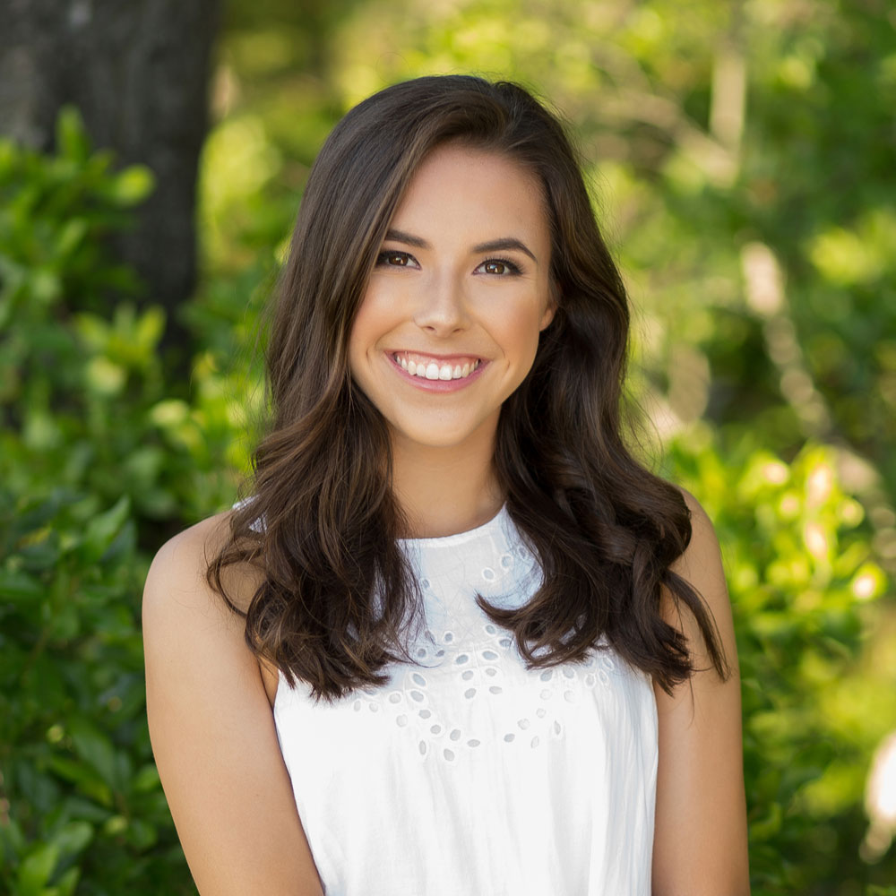 Portland senior with green background smiling at camera