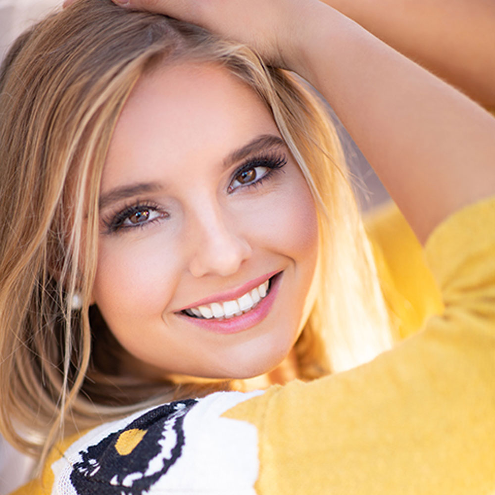 Portland senior in yellow, smiling at the camera
