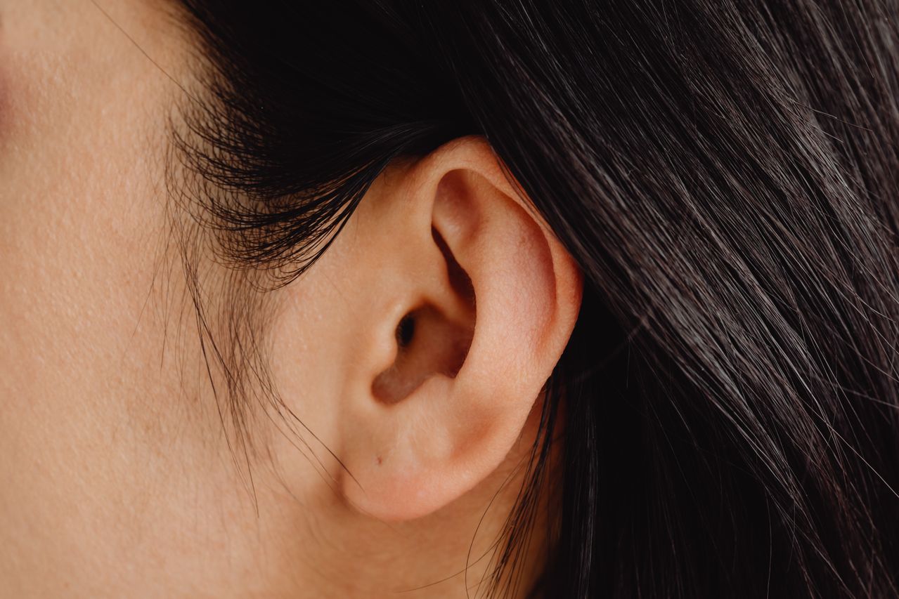 Gros plan sur l'oreille d'une femme aux cheveux bruns