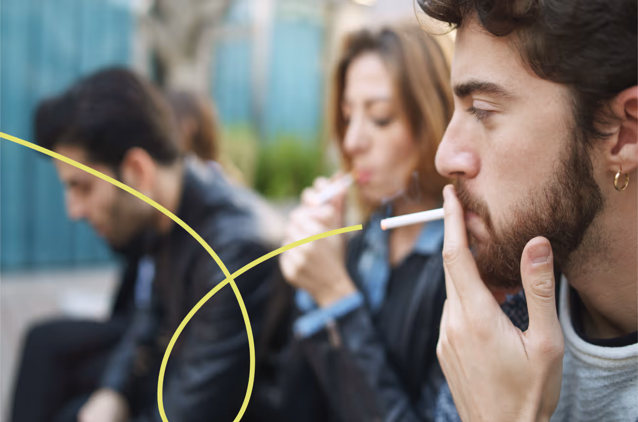 Group of people sitting outside smoking cigarettes