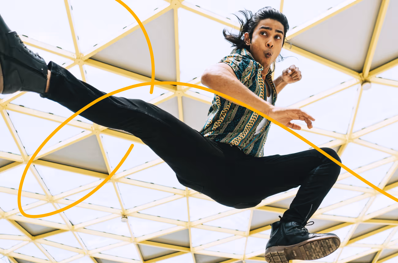 Man with long hair jumping and kicking