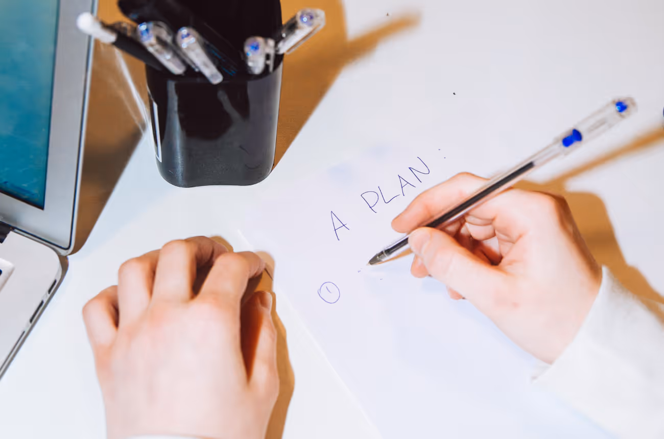 Person writing a plan on paper