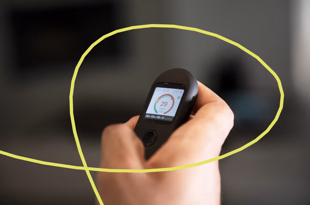 Person holding Pivot Breath Sensor with a 29 reading on the screen 