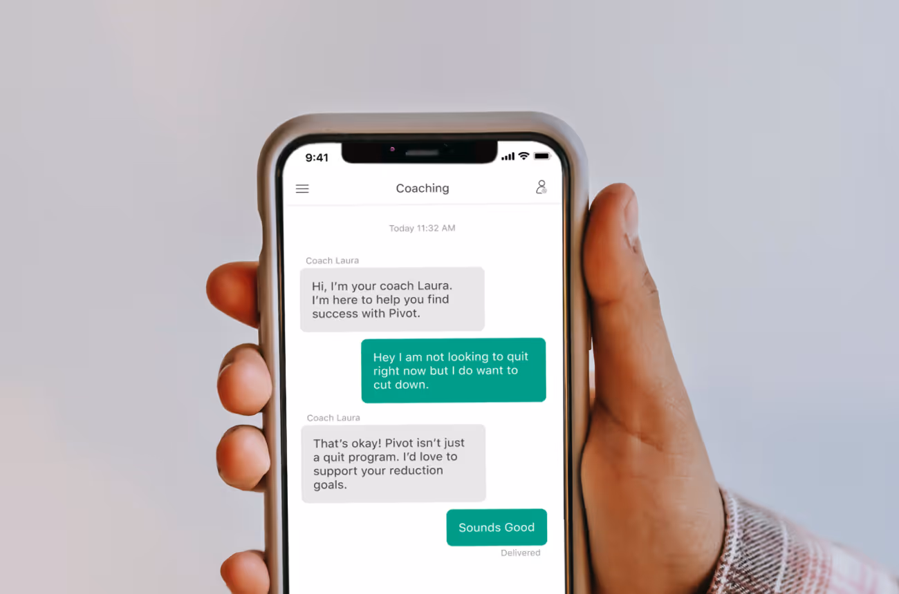 Man's hand holding up a phone screen with messages on it