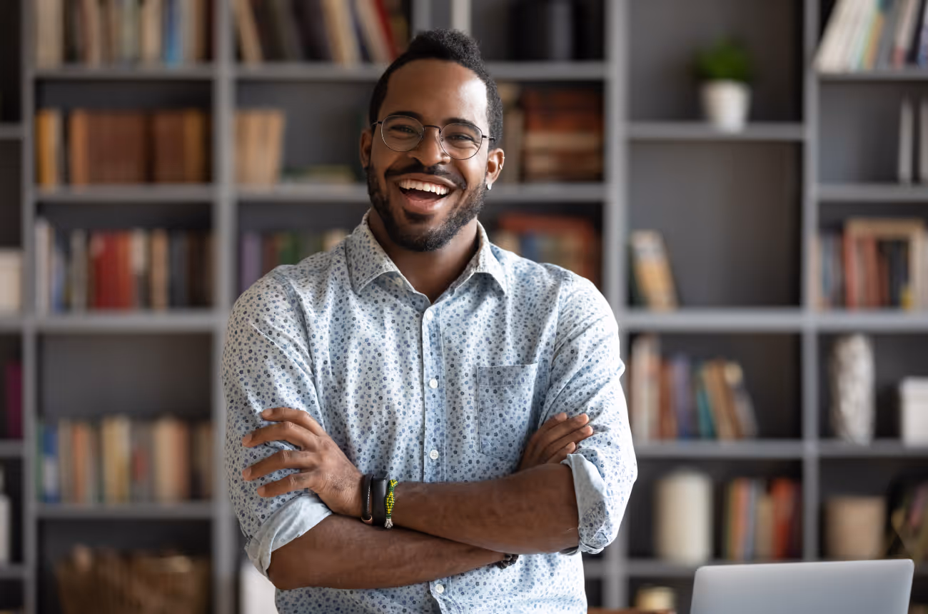Man standing looking at camera with folded arms smiling 