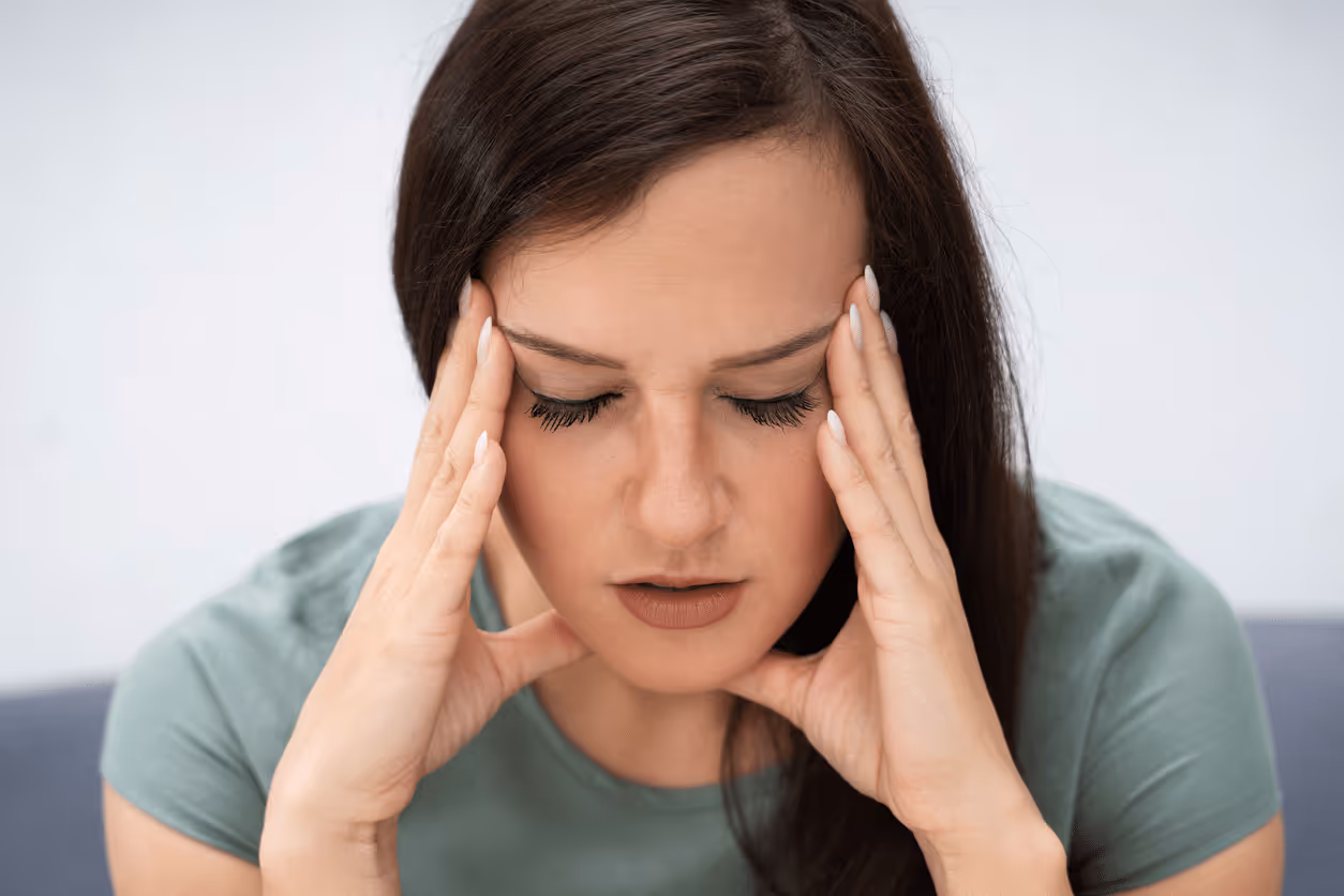 Woman holding heading in hands looking frustrated 