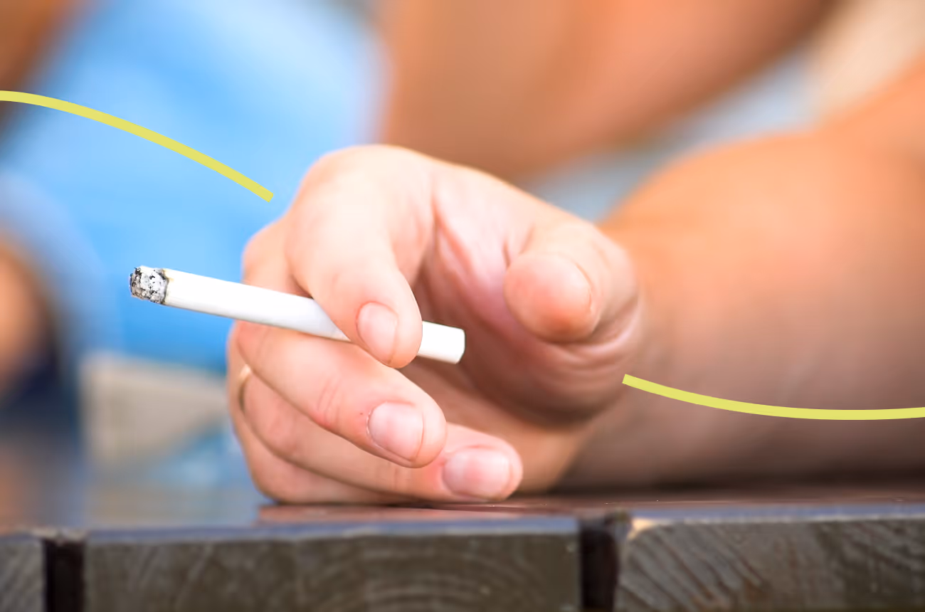 hand holding cigarette with a yellow line across it