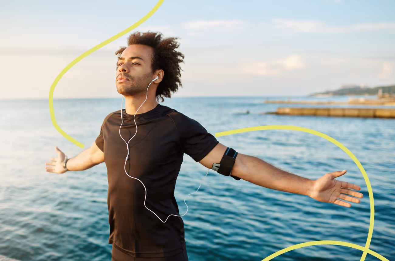 man with headphones in breathing deeply with arms stretched out