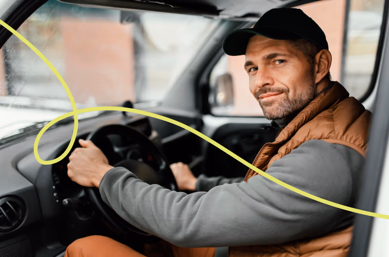 man wearing hat driving a car while looking at the camera