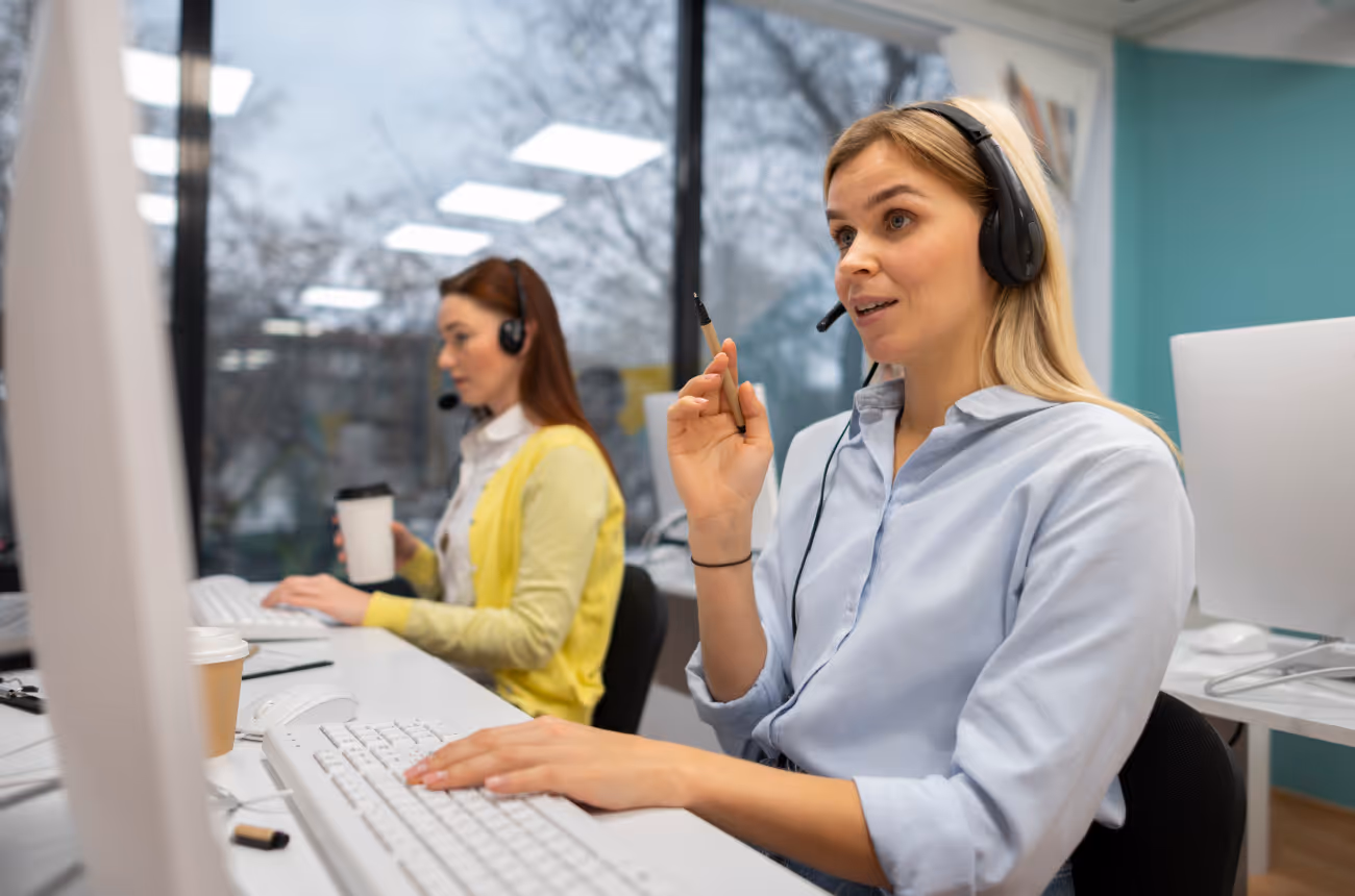 employees wearing headsets sitting at computers 