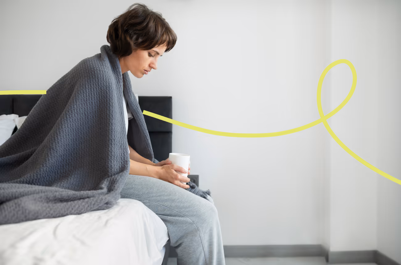 woman sitting on bed sadly