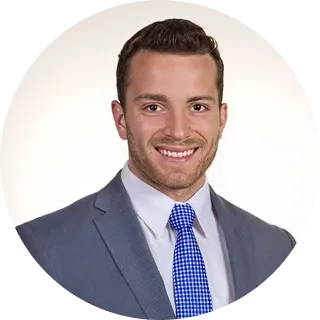 Smiling business professional in a blue suit and tie with short brown hair in a circle frame.
