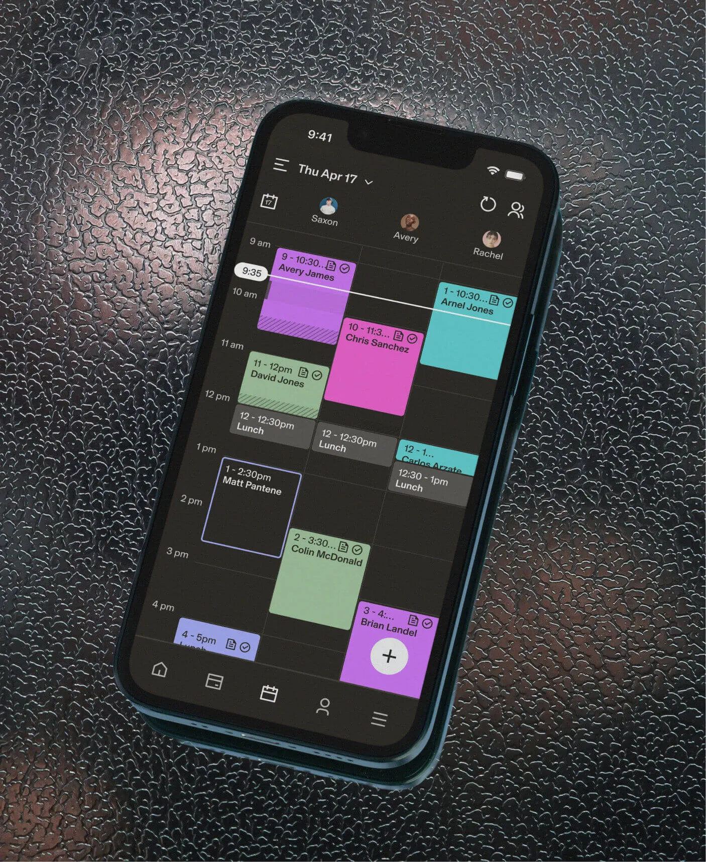 A smartphone displaying a color-coded calendar for barber software scheduling.