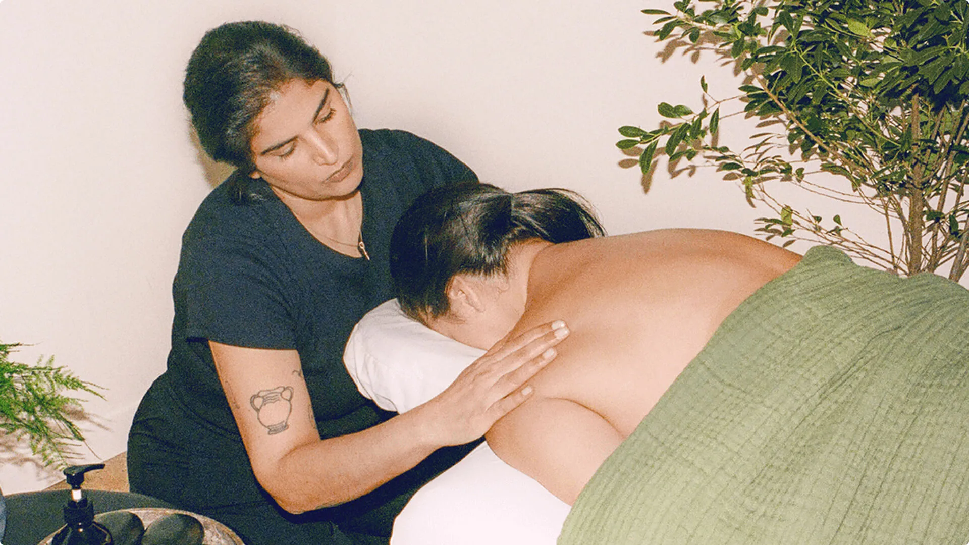 A massage therapist working the shoulders of a face down client