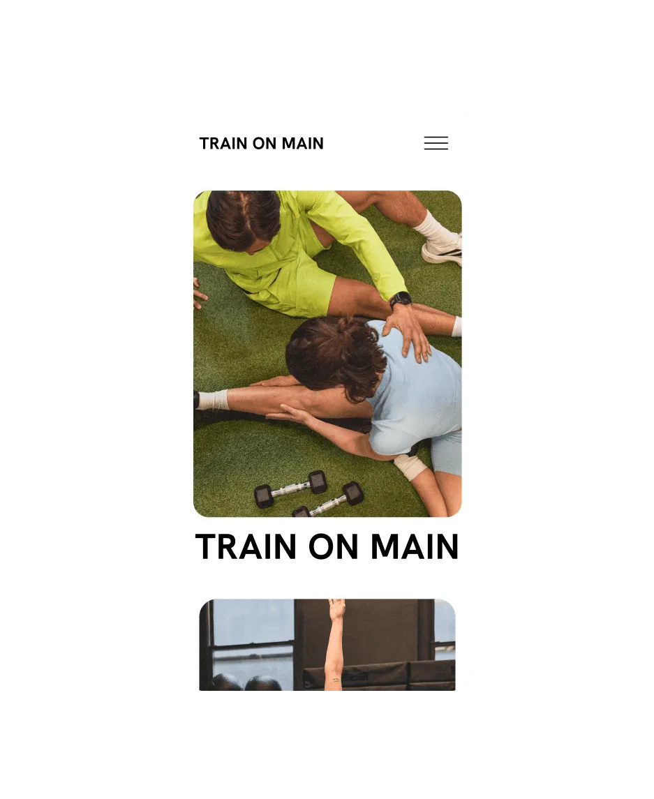 A mobile view of a fitness coach helping their client stretch their leg while seated on the ground for the Train on Main website