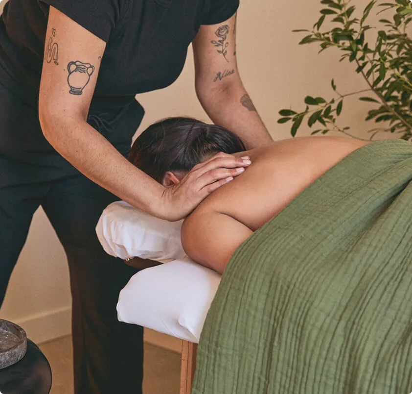 Image of a massage therapist giving a shoulder massage to a customer.