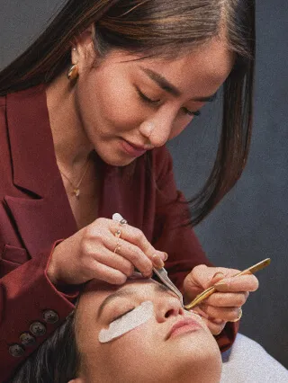 A lash artist working on a client