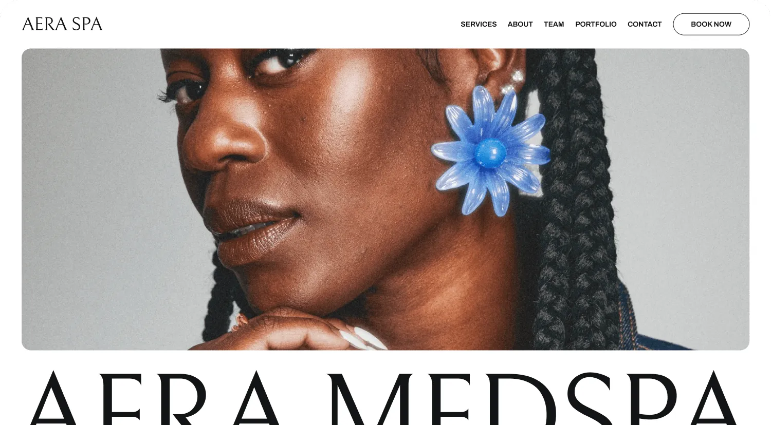 Desktop view of Aera Spa booking site featuring image of the side of a woman’s face wearing a big blue flower earring