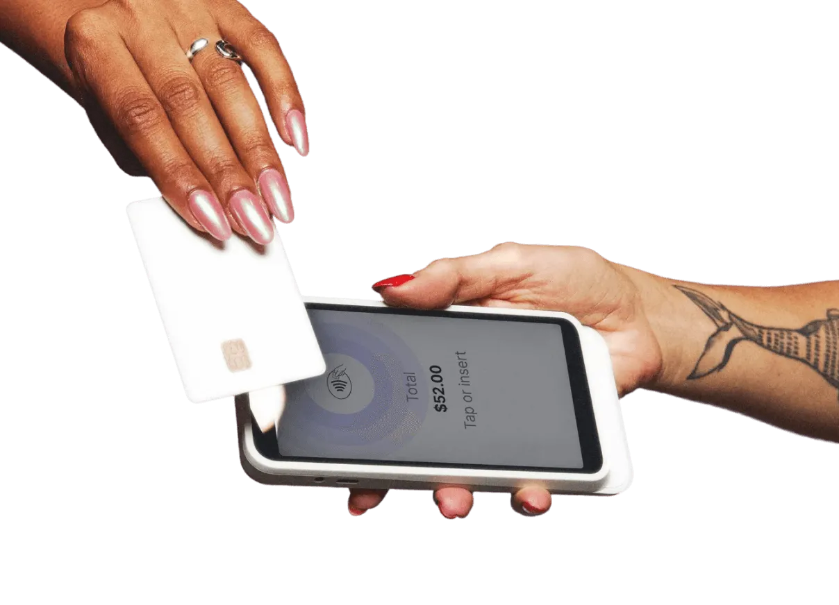 A manicured hand with pink nails holding a white card over the GlossGenius Pro Reader to check out.