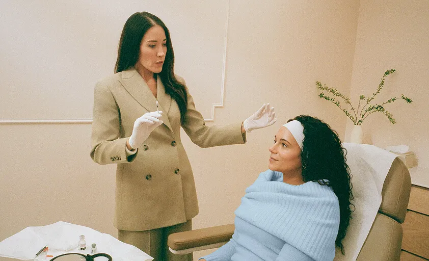 A woman’s hands holding a phone displaying a color-coded calendar