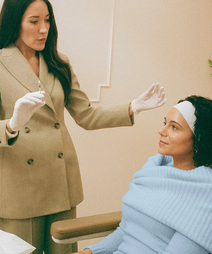 Larger image of provider getting ready to apply treatment to a woman’s face