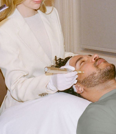 Image of an esthetician applying treatment to a medspa client’s face 