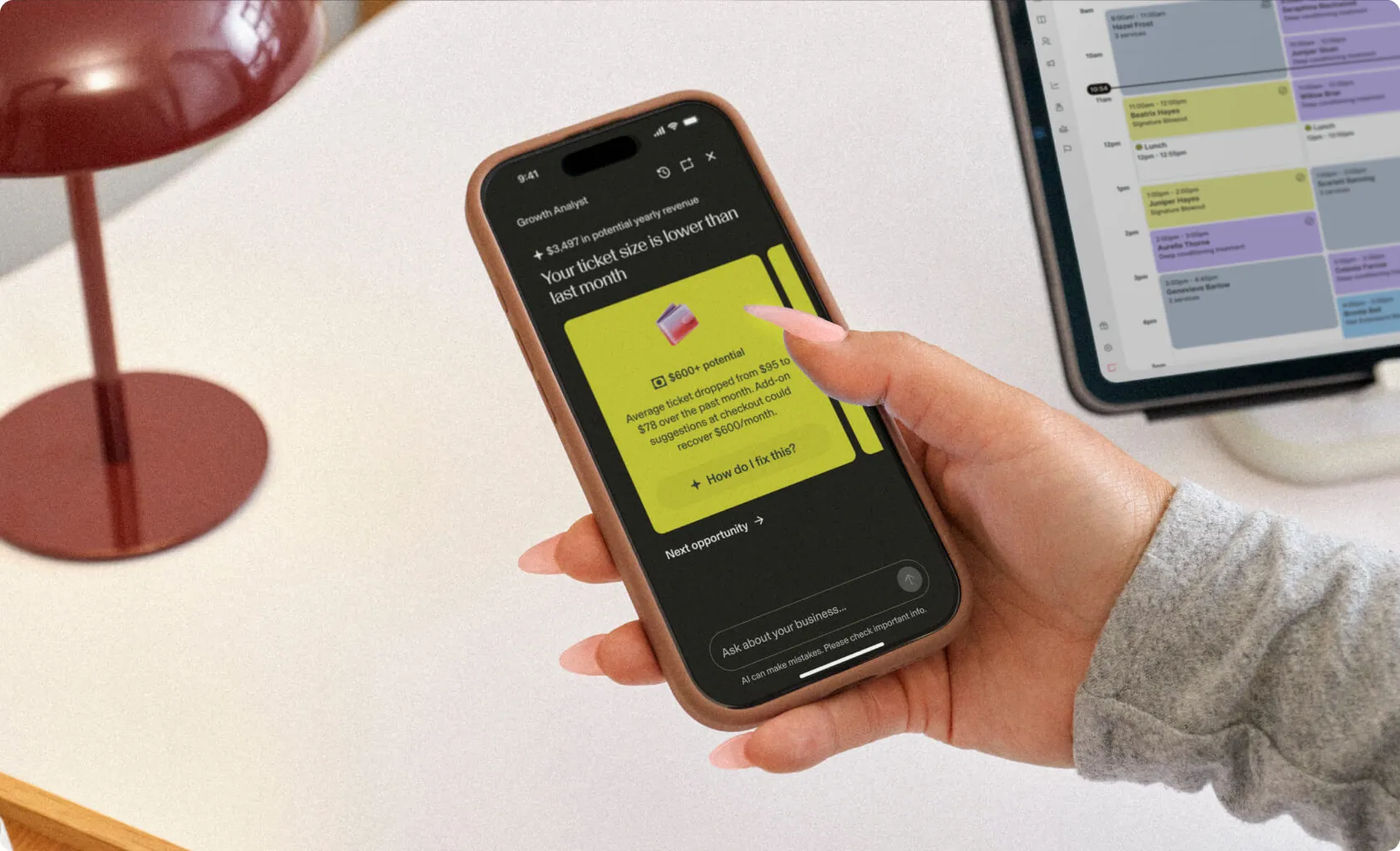 A woman’s hands holding a phone displaying a color-coded calendar