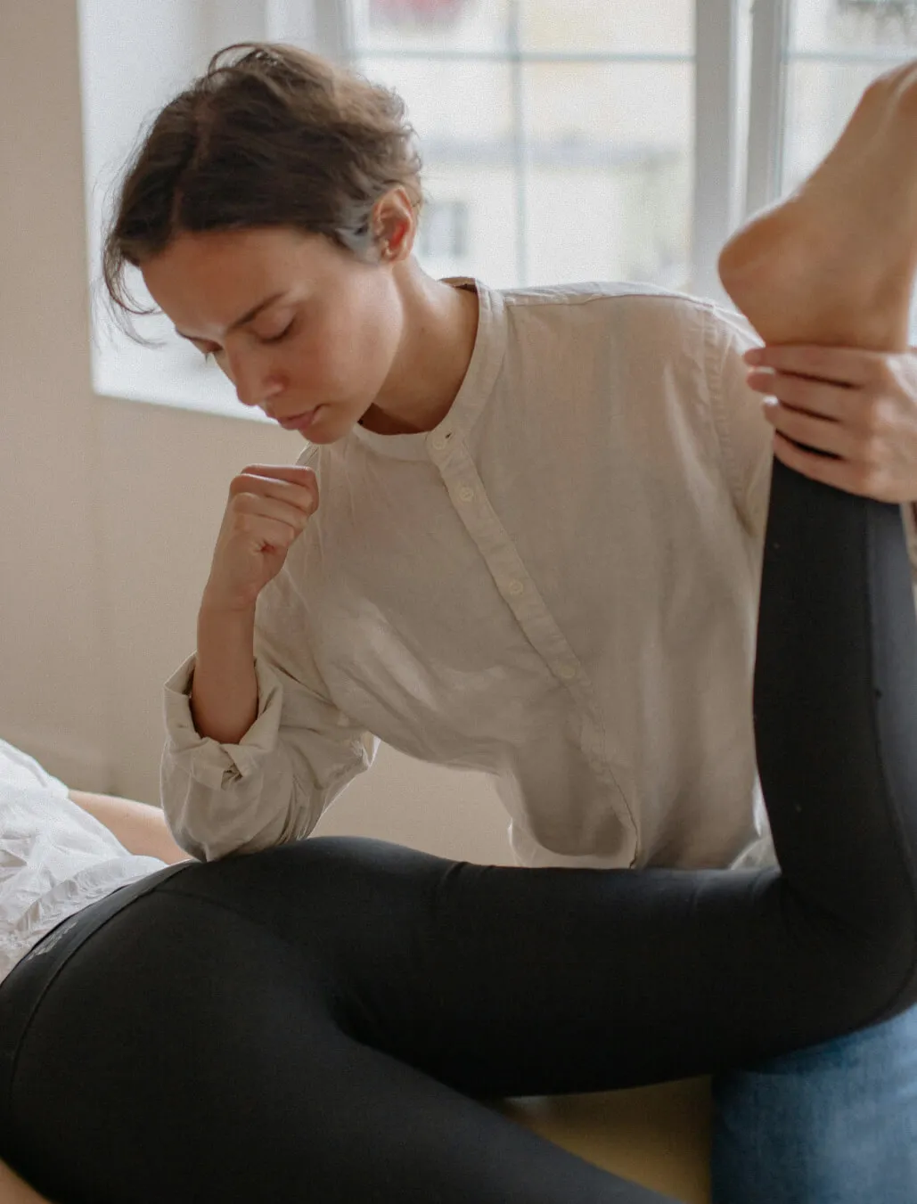 Chiropractor's hands resting on a patient's upper back during a gentle realignment.
