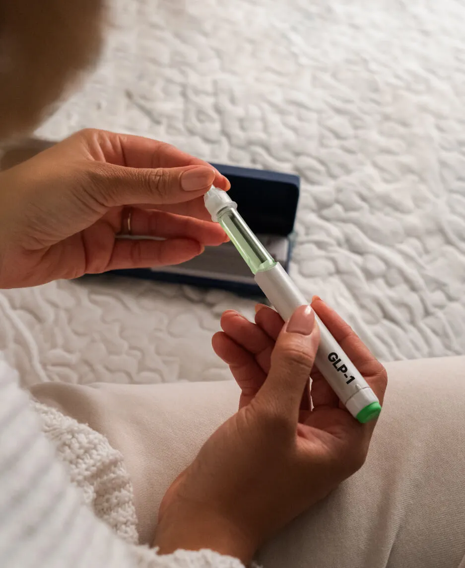 A clinician's gloved hands preparing a labeled GLP-1 injection pen at a medical weight loss clinic.