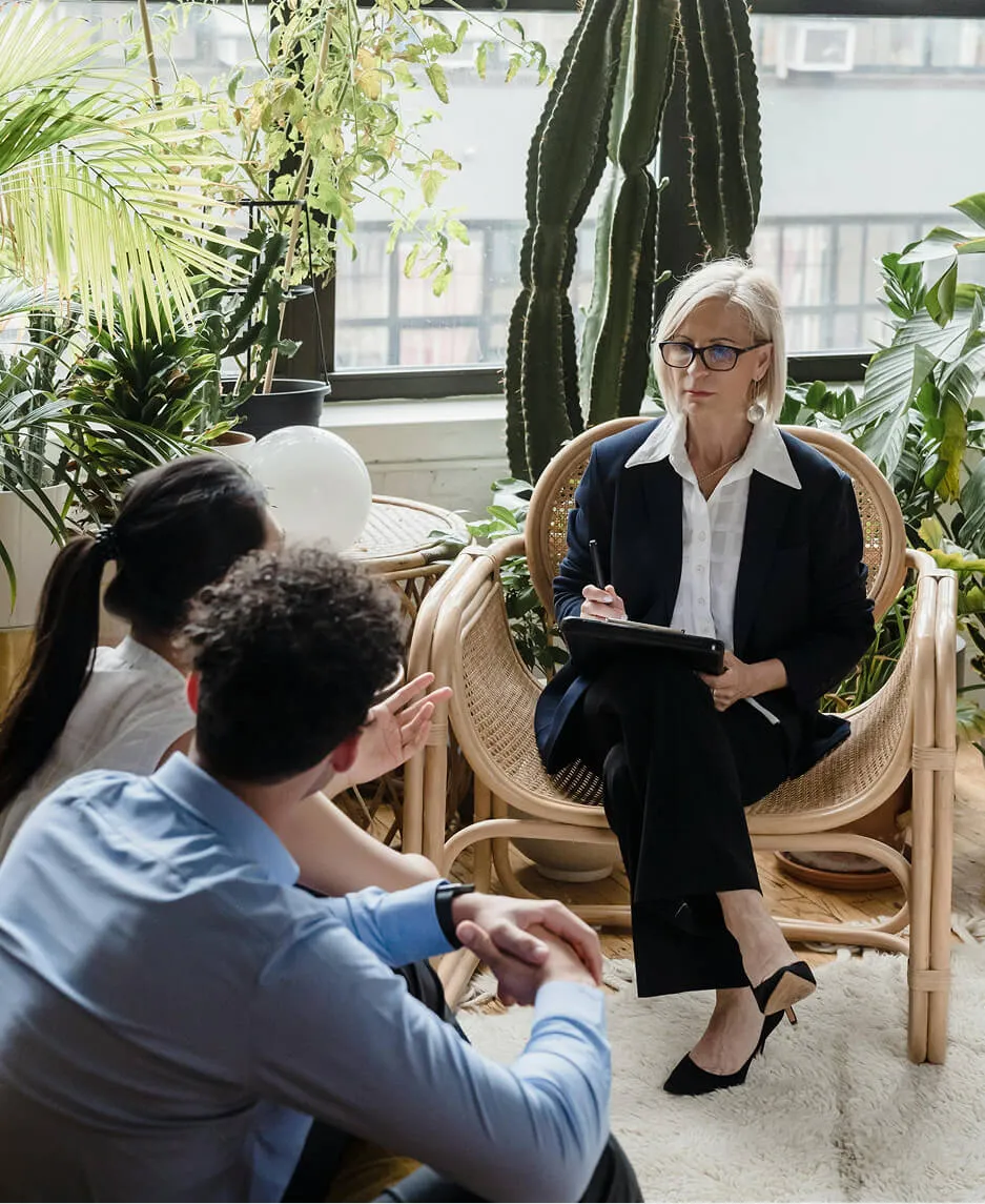 A therapist and client in conversation across facing couches during a session at a behavioral health practice.