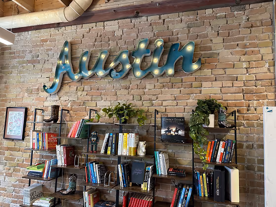bookshelf with Austin signature on the wall