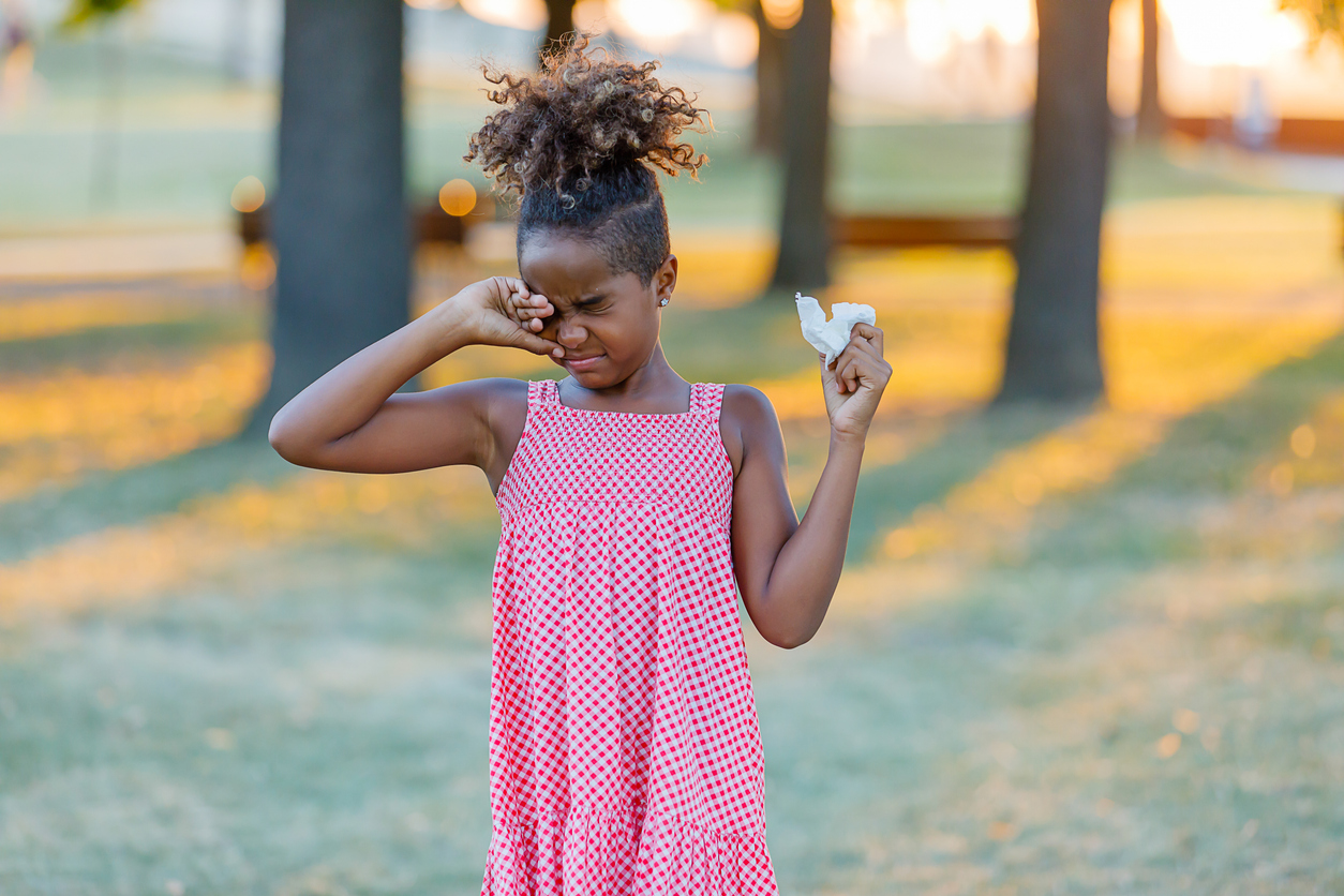 A young girl holding a piece of food in her hand