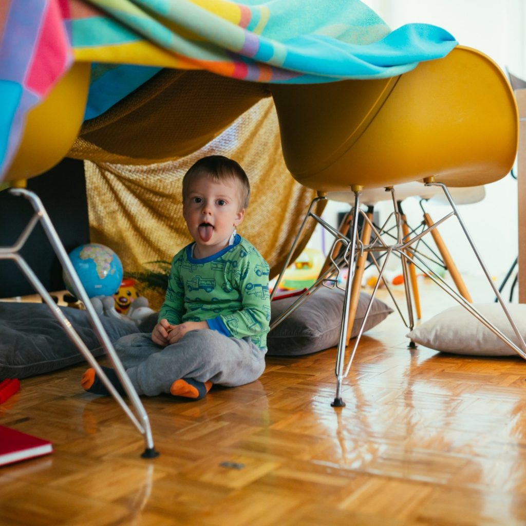 Child plays in a homemade fort