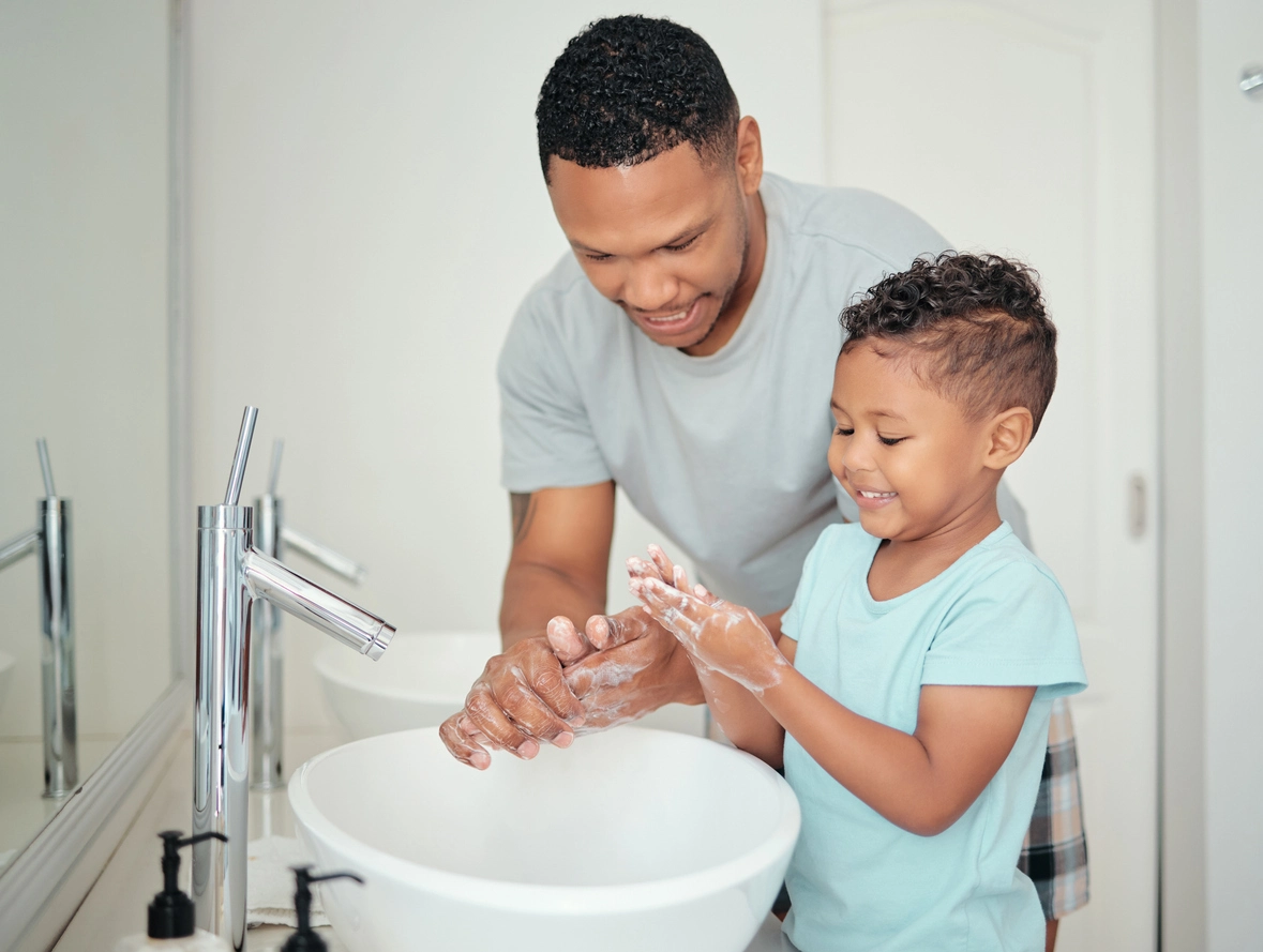 A father and son washing their hands at the bathroom sink Blueberry Pediatrics