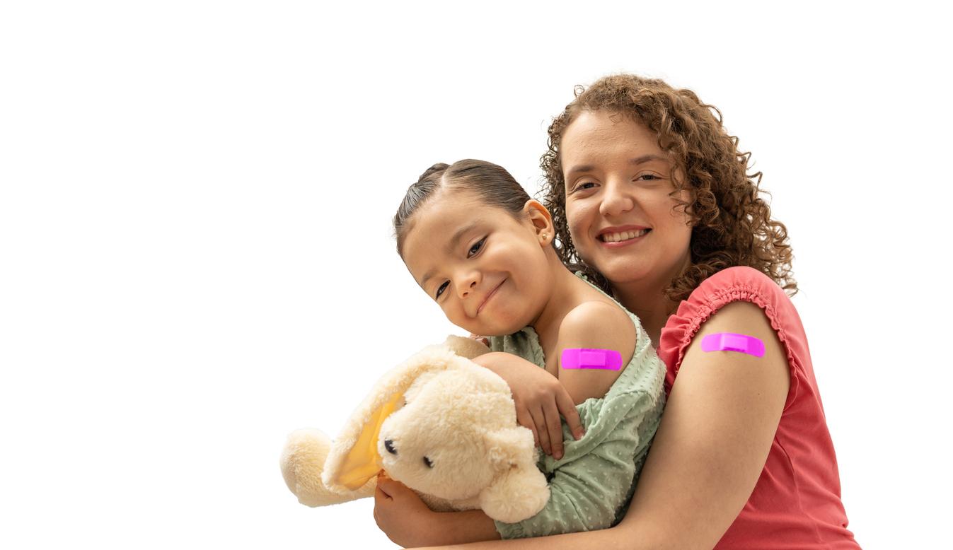 Mother and daughter with pink band aid smiling after having an injection.