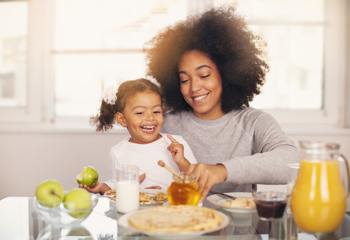 African American mother and daughter having breakfast together