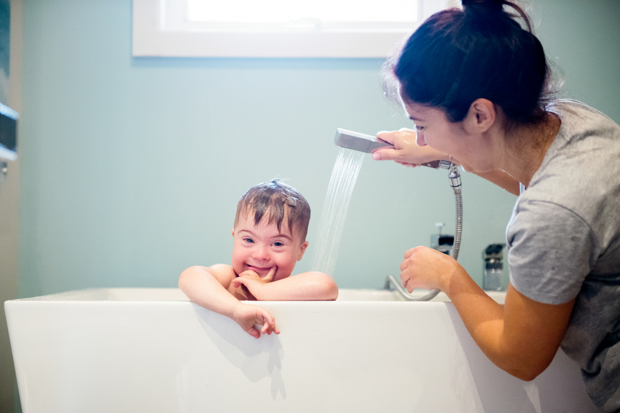 A mom holding a shower head over her son in the bath tub Blueberry Pediatrics medical consultation