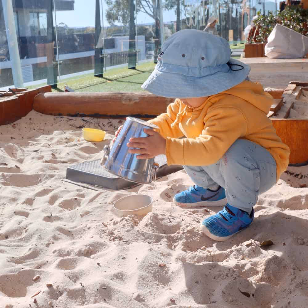 Young child playing in sandpit