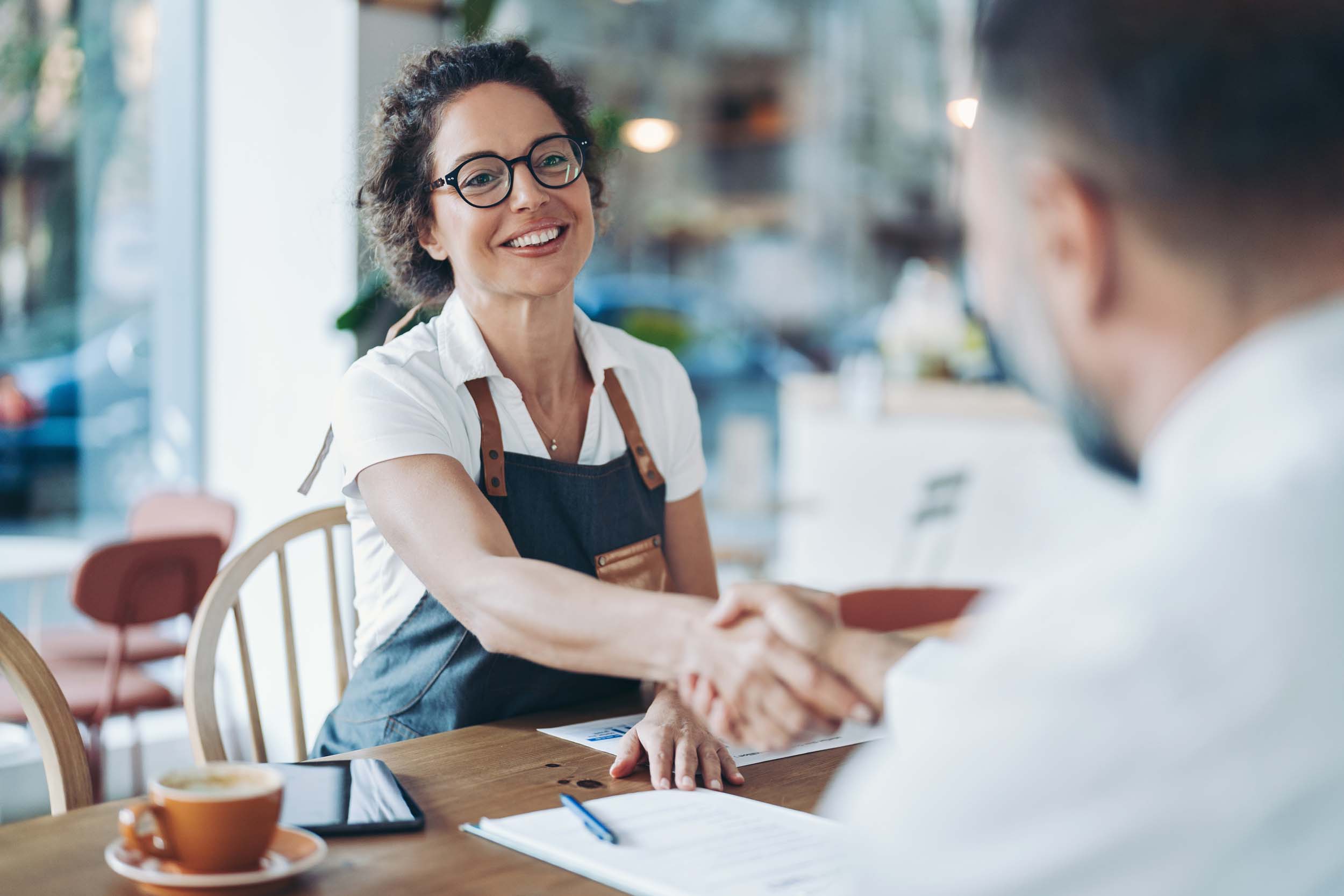 Smiling business owner shaking hands with their accountant