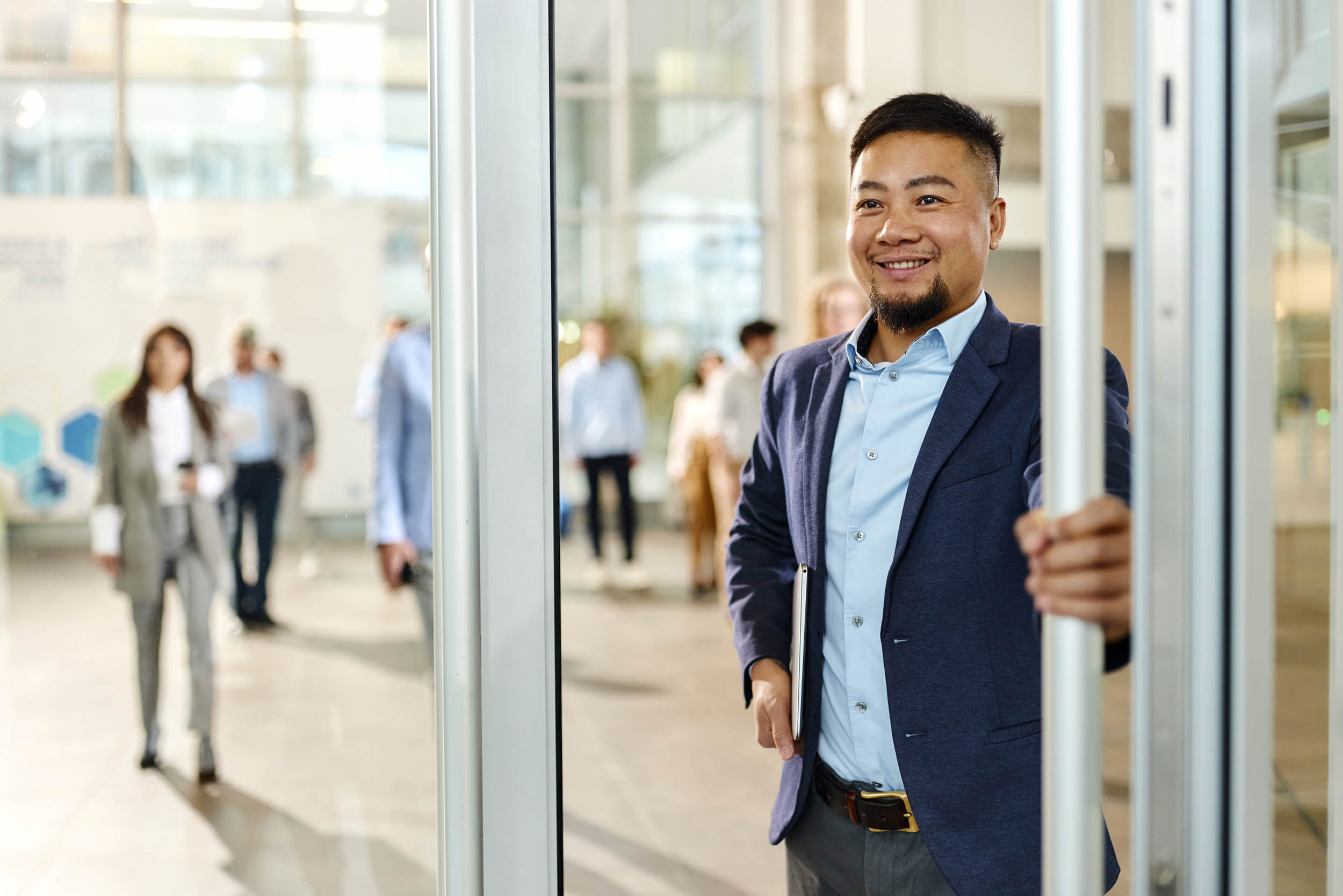Professional warmly welcoming a client through an open door