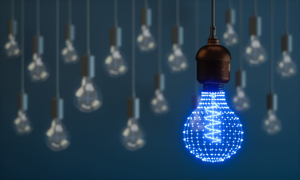 A light bulb made from digital light dots among other lightless bulbs. Digital presence and idea.