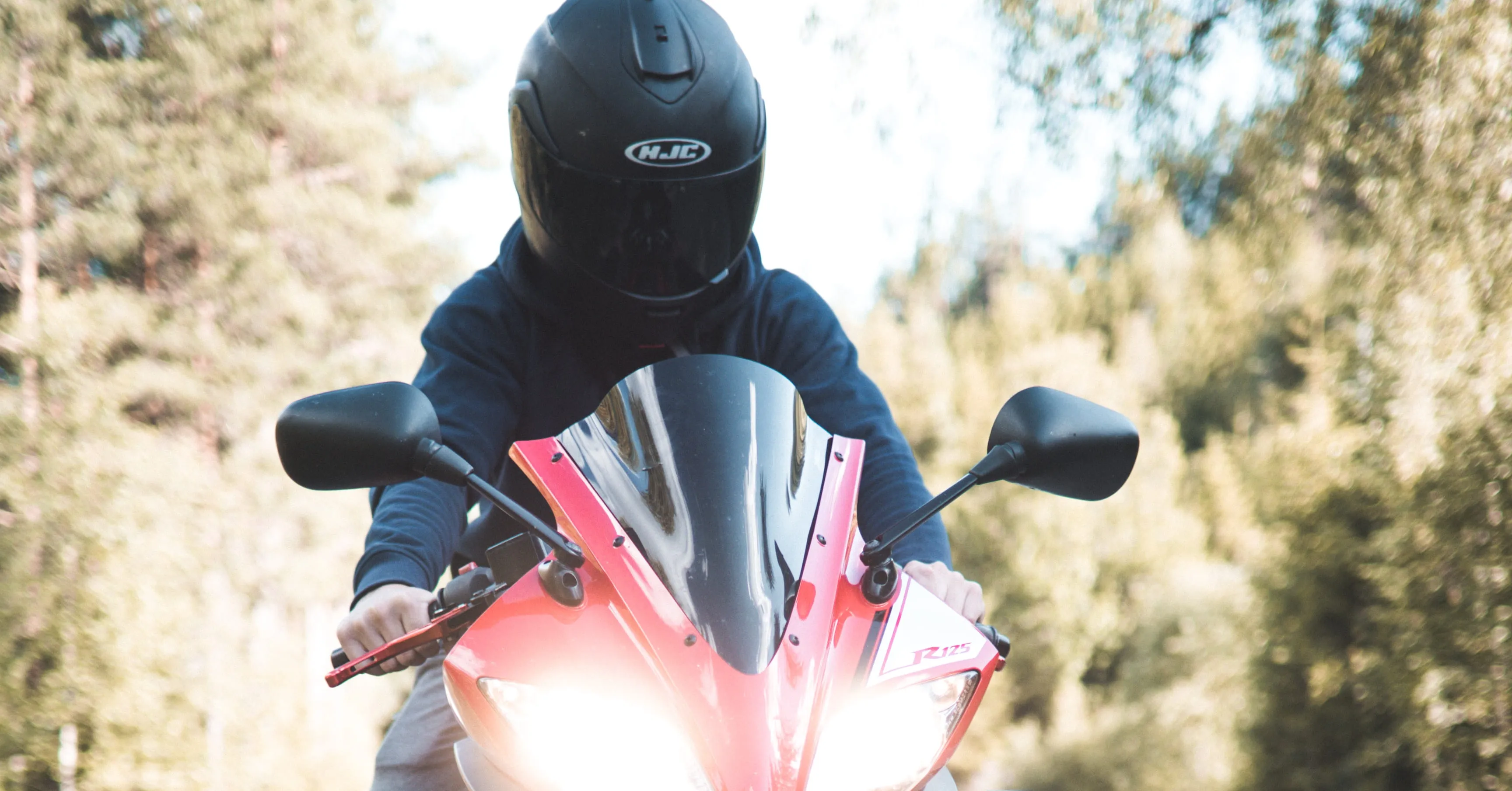 chico en moto roja con casco integral