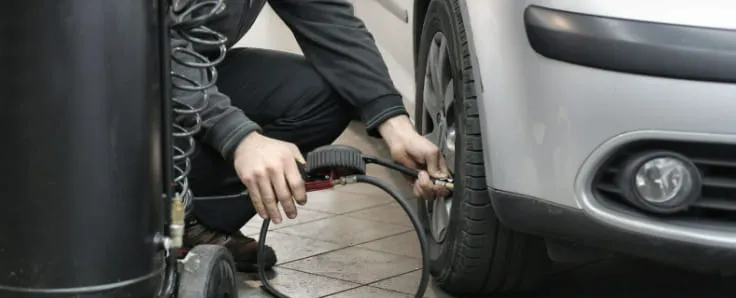 persona hinchando rueda de coche
