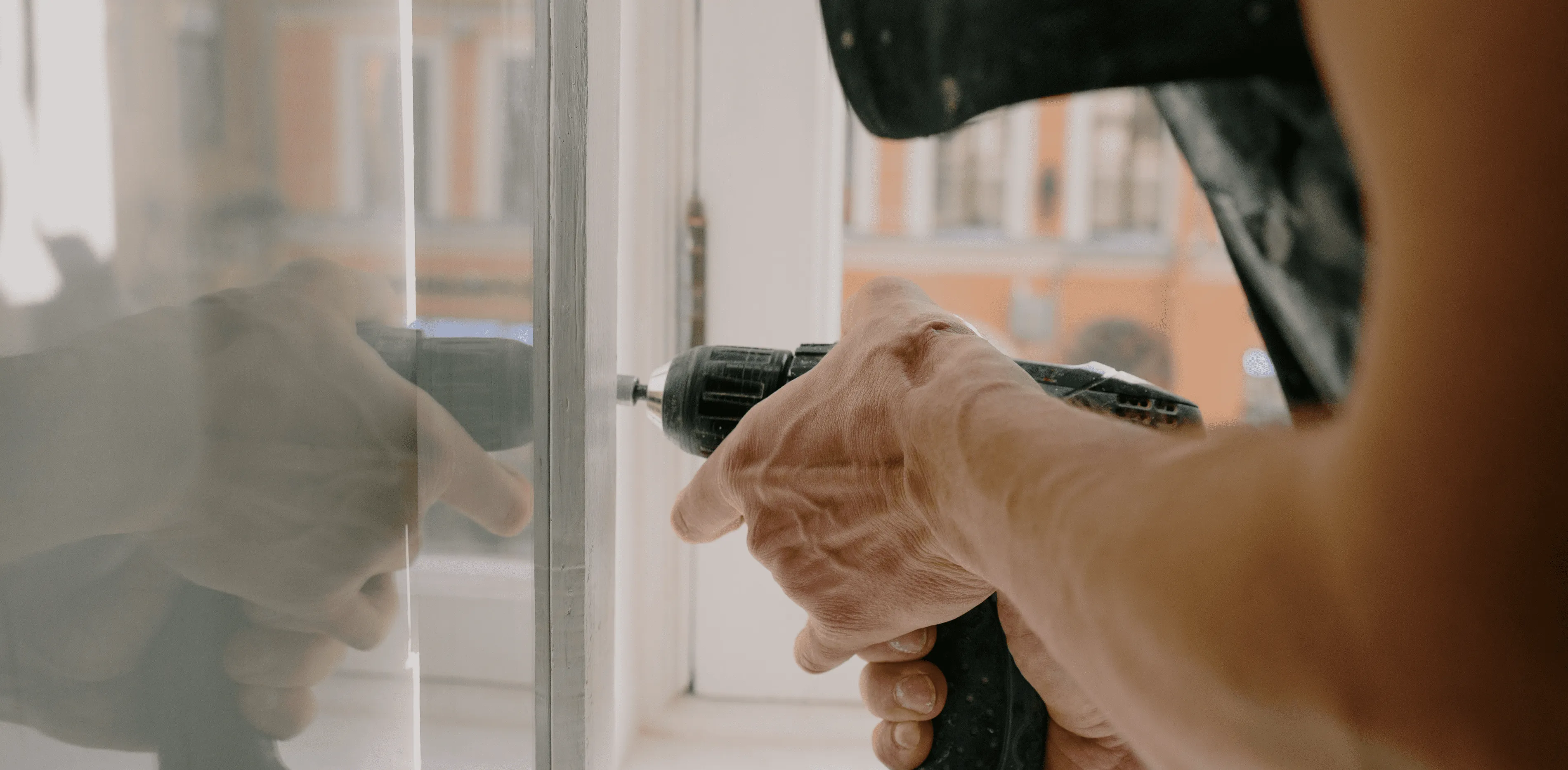 persona arreglando un bajo de una ventana