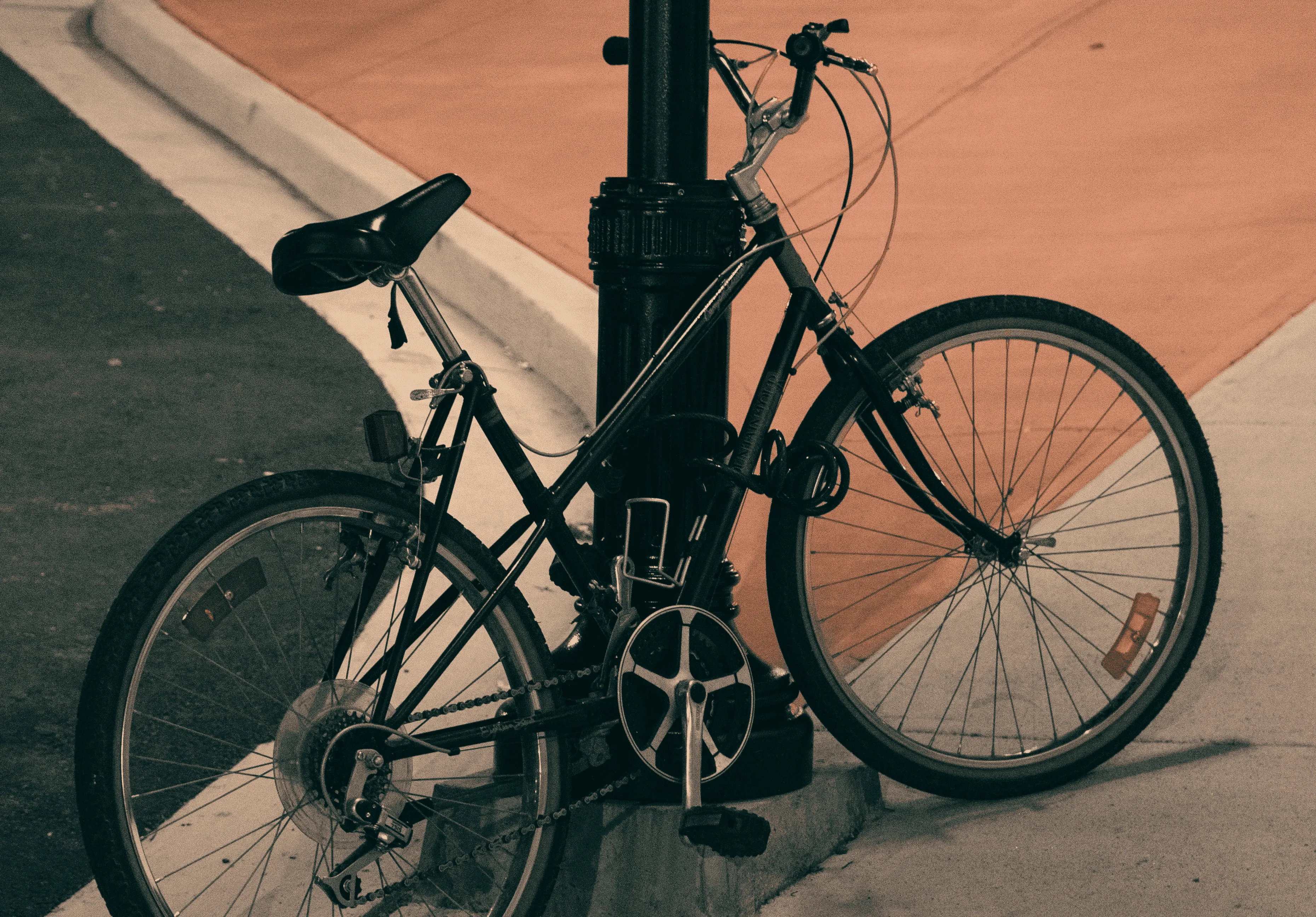 bicicleta negra encadenada en medio de la ciudad