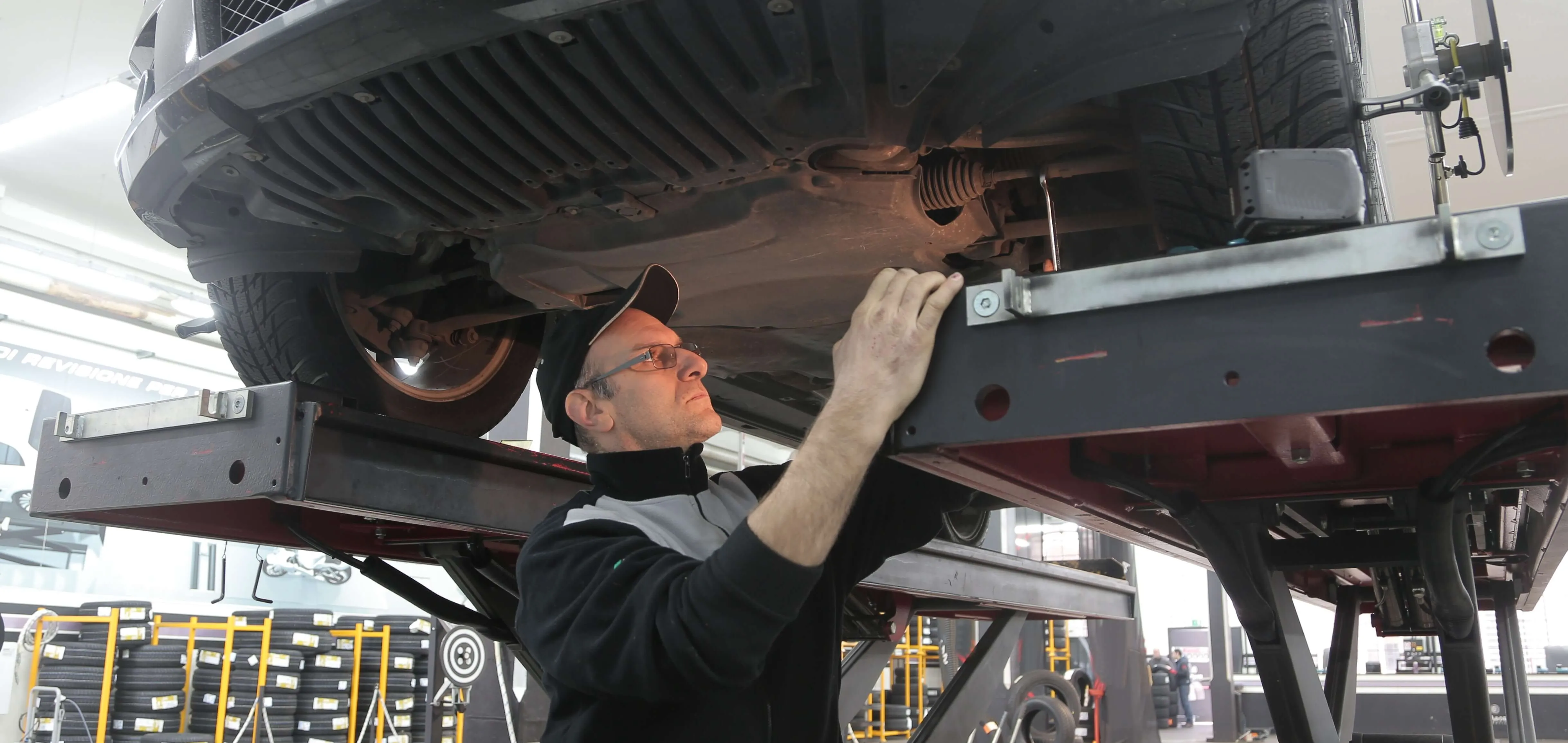 hombre con gorra y gafas revisando coche