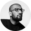 Hombre con barba y gafas, mirando hacia un lado, fondo blanco y con un estilo moderno.