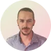 Hombre con cabello corto y barba, vestido con camisa de mezclilla, fondo circular con degradado de colores.