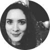Retrato en blanco y negro de una mujer con cabello rizado, sonriendo y mirando a la cámara.