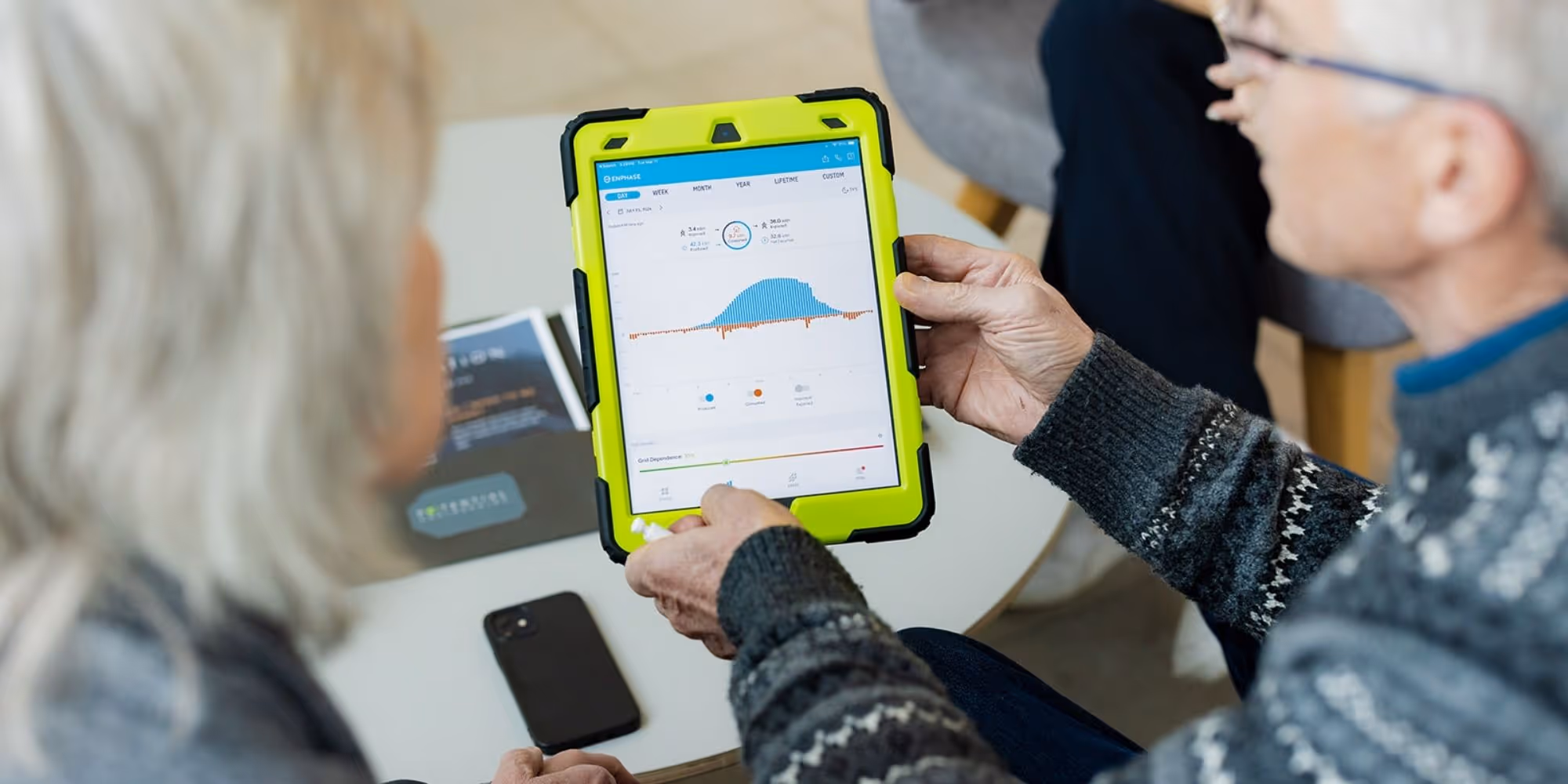 couple looking at energy monitoring system Enphase Enlighten solar app